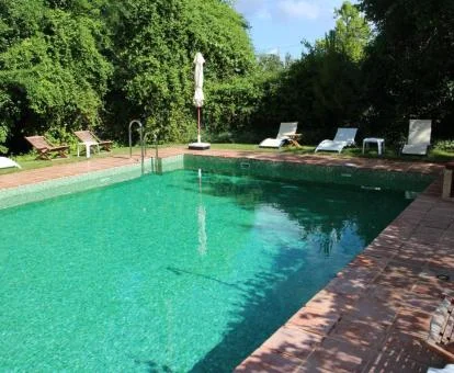 Piscina exterior de este precioso hotel romántico rodeada de vegetación.