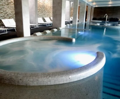 Piscina cubierta con elementos de hidroterapia del spa del hotel.