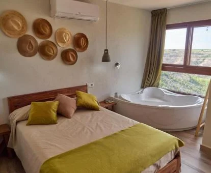 Dormitorio con bañera de hidromasaje privada junto a la cama de este coqueto alojamiento.