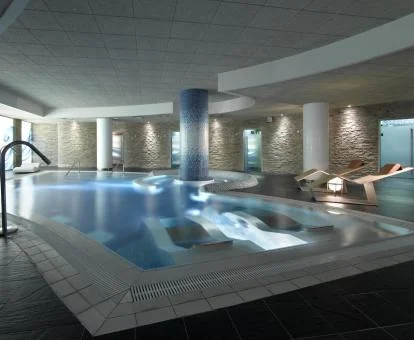 Piscina cubierta con elementos de hidroterapia del spa del hotel.