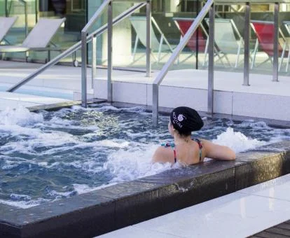 Mujer disfrutando de la piscina con hidroterapia de este hotel solo para adultos.