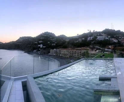 Piscina exterior con vistas al mar y a los alrededores de este hotel con encanto.