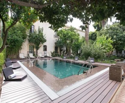 Preciosa zona exterior con piscina rodeada de vegetación del hotel.