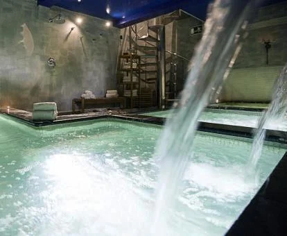 Piscina cubierta con elementos de hidroterapia del spa del hotel.