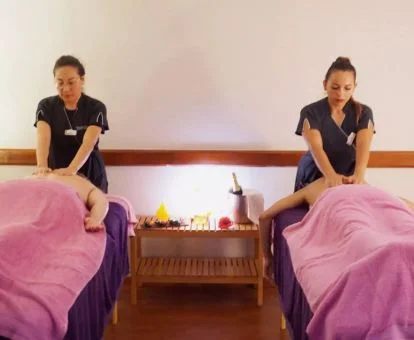 Pareja disfrutando de un masaje doble en la sala de bienestar del spa.