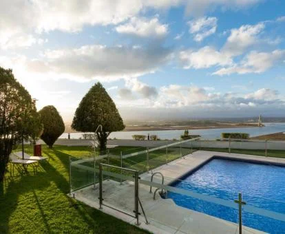 Piscina exterior rodeada de jardines con vistas al mar de este hotel con encanto.--