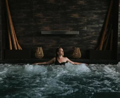 Mujer disfrutando de la zona de aguas del centro de bienestar del hotel.