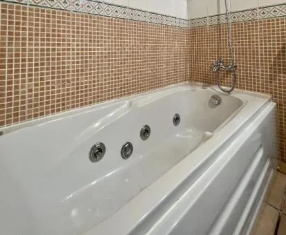 Bañera de hidromasaje privada en el baño del apartamento de un dormitorio de este establecimiento.