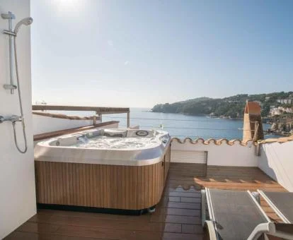 Agradable terraza con un gran jacuzzi privado y vistas al mar de este ático.