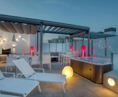 Fabulosa terraza amueblada con un gran jacuzzi en funcionamiento al aire libre.