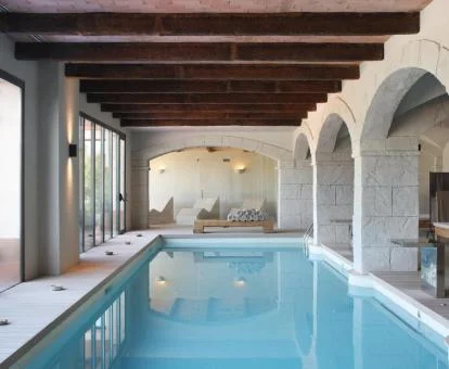 Piscina cubierta con amplios ventanales y vistas al exterior de spa del hotel.