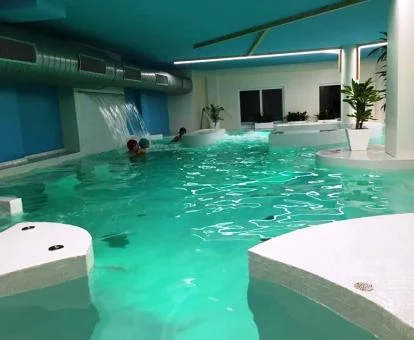 Varias personas disfrutan de la piscina de hidroterapia del spa de este hotel con encanto.