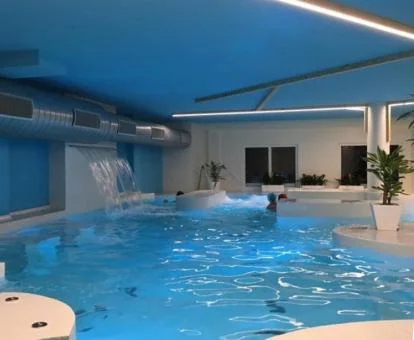 Piscina cubierta con elementos de hidroterapia del centro de bienestar del hotel.