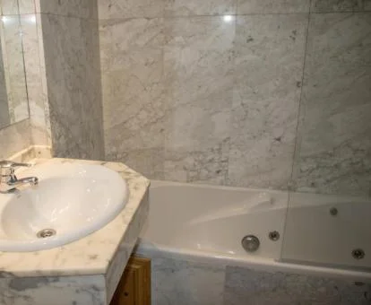 Baño con bañera de hidromasaje privada de este apartamento.