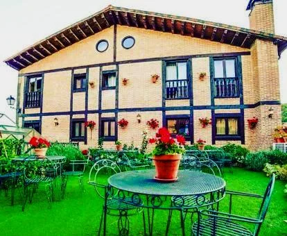 Edificio de este hotel rural con jardín y comedores exteriores.
