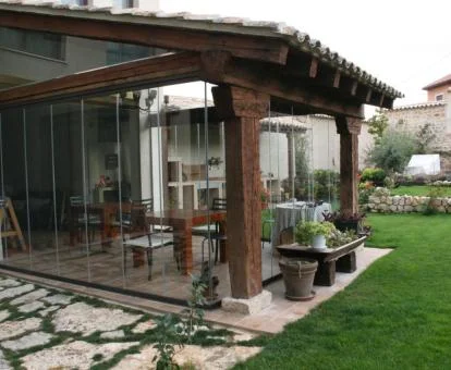 Agradable zona exterior ajardinada con terraza cubierta de este hotel boutique.