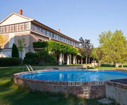 Hotel con encanto con amplios jardines y piscina exterior.