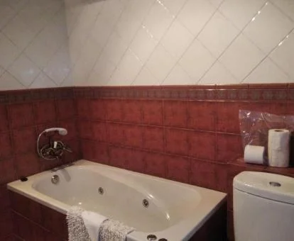 Baño con bañera de hidromasaje privada de este apartamento rural.