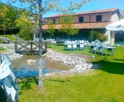 Hermosa posada con bellos jardines y un estanque.