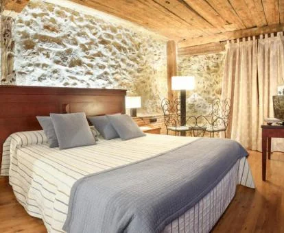 Una de las habitaciones de estilo tradicional con paredes de piedra a la vista de este hotel spa.