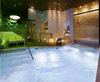 Piscina cubierta con elementos de hidroterapia y zona de relajación del hotel.