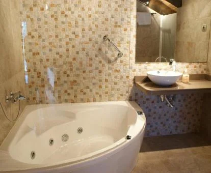 Bañera de hidromasaje privada del ático de este establecimiento.