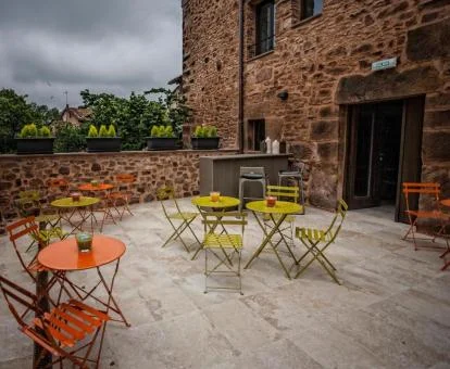 Edificio de piedra de este hotel boutique con terraza y comedor exterior.