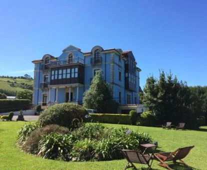 Espectacular edificio de este hotel boutique con hermosos jardines y mobiliario exterior.