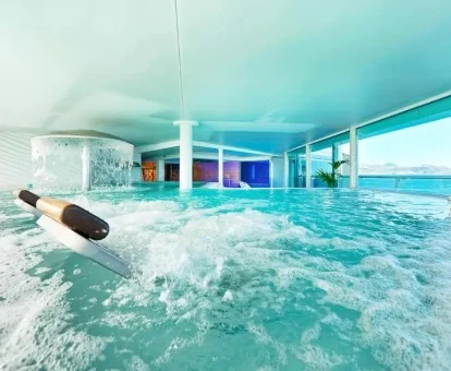 Piscina cubierta con hidroterapia y vistas al mar del centro de bienestar del hotel.