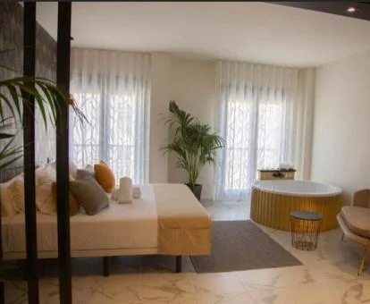 Dormitorio con jacuzzi privado cerca de la cama de uno de los apartamentos.