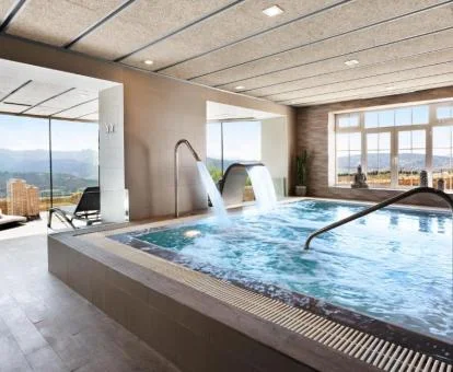 Preciosa piscina cubierta con hidroterapia y vistas al exterior del centro de bienestar del hotel.