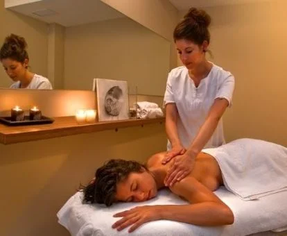 Mujer disfrutando de un masaje en la sala de bienestar del spa.