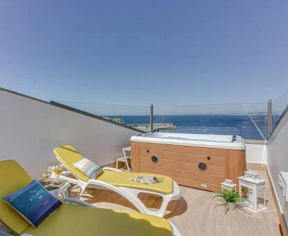 Terraza privada con un gran jacuzzi y vistas al mar de uno de los apartamentos del establecimiento.