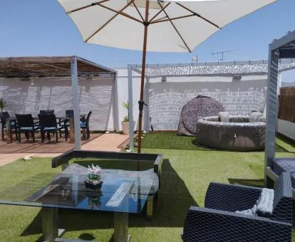 Terraza amueblada con jacuzzi privado exterior del apartamento con vistas a las montañas.