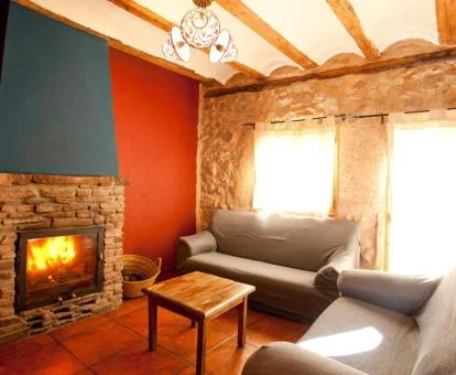 Acogedora sala de estar con chimenea y sofás de esta casa rural.
