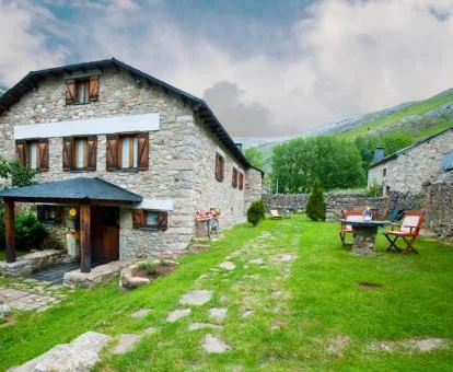 Edificio de piedra de este hotel rural con amplios jardines y mobiliario.