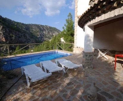 Zona exterior con piscina privada de una de las casas rurales de este alojamiento en medio de la naturaleza.