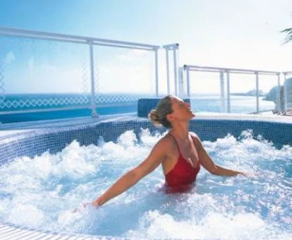 Mujer disfrutando del jacuzzi al aire libre del spa.