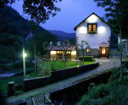 Hermoso edificio rural con amplios jardines y mobiliario al aire libre.