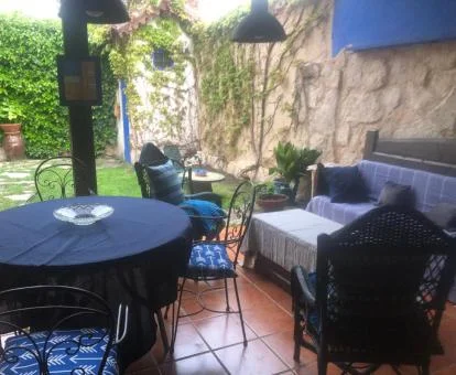 Zona exterior con mobiliario y jardín de esta acogedora casa rural.