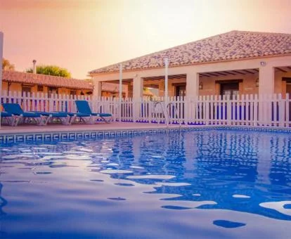 Complejo de casas rurales con gran piscina al aire libre.