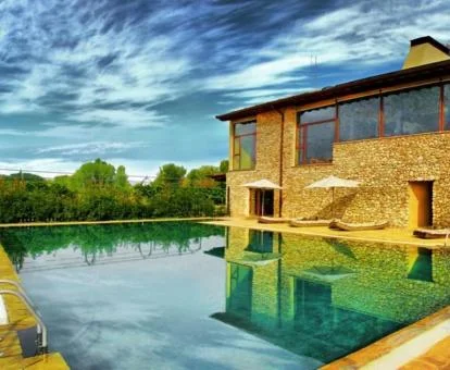 Edificio de este hotel de piedra con gran piscina y vistas a la naturaleza.