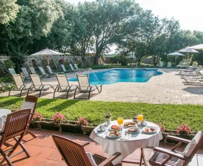 Bellos exteriores de este hotel con piscina rodeada de jardines.