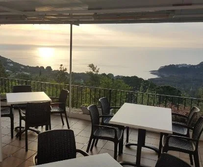 Comedor con amplios ventanales y vistas a la naturaleza y al mar de este alojamiento rural.