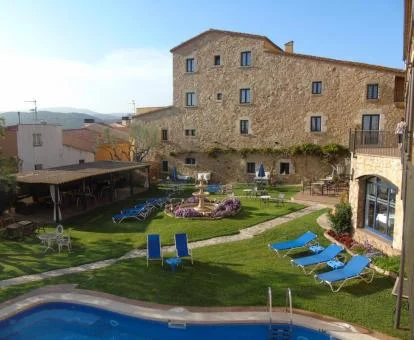 Agradable zona exterior ajardinada con mobiliario y piscina de este hotel boutique.