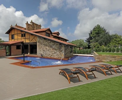 Precioso hotel rural con piscina con chorros de hidroterapia en el exterior.