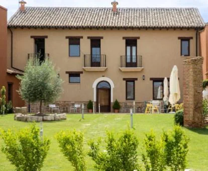 Hotel rural con amplios jardines y mobiliario exterior.