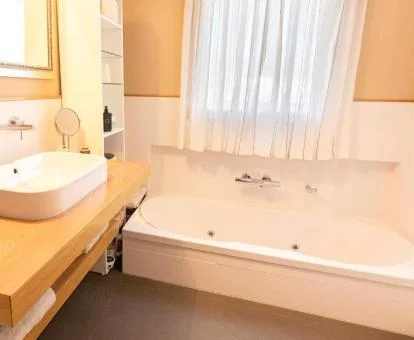 Baño con bañera de hidromasaje privada del apartamento dúplex de este establecimiento.