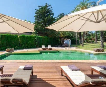 Piscina exterior rodeada de jardines de este bonito hotel.