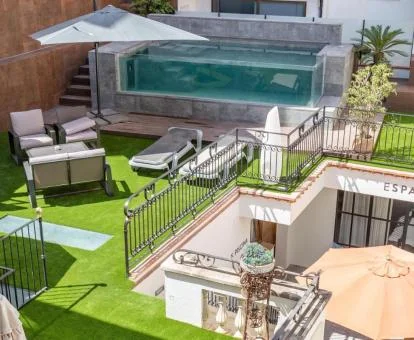 Terraza de este coqueto hotel con mobiliario exterior y piscina.